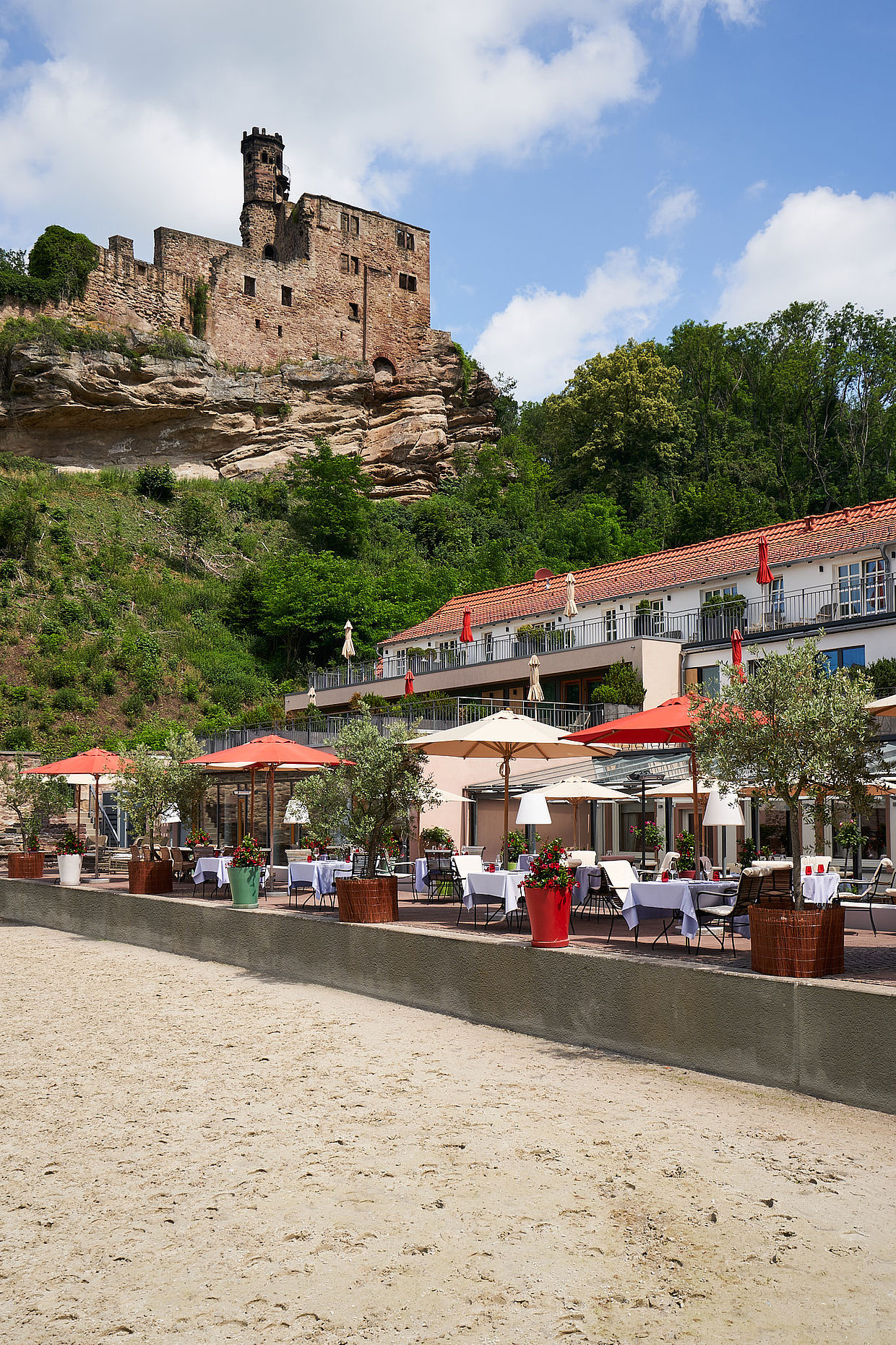 Außenansicht des Hotels unter der Burgruine und der dazugehörigen Restaurant Terrasse