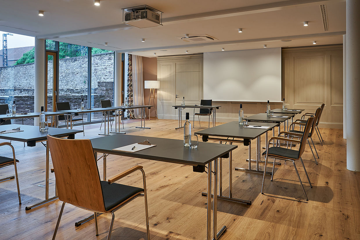 In U-Form arrangierte Tische und Stühle für ein Präsentationstreffen im Hoppegarten Raum