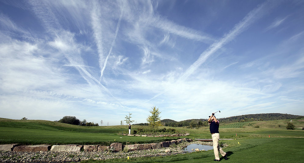 Ein Golfspieler schwingt seinen Golfschläger auf dem Golfplatz vom Hardenberg BurgHotel