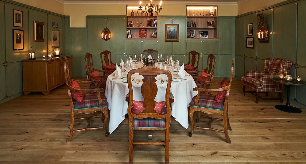 Fein gedeckter runder Tisch mit weißen Leintüchern und Stühlen in historisch eleganter Lounge.Fein gedeckter runder Tisch mit weißen Leintüchern und Stühlen in historisch eleganter Lounge.
