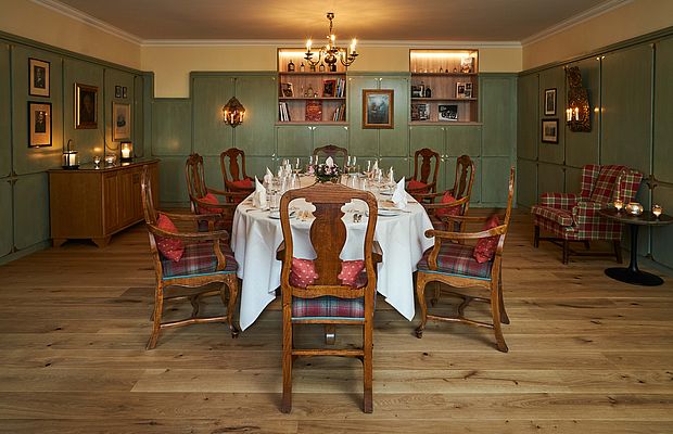 Fein gedeckter runder Tisch mit weißen Leintüchern und Stühlen in historisch eleganter Lounge.Fein gedeckter runder Tisch mit weißen Leintüchern und Stühlen in historisch eleganter Lounge.
